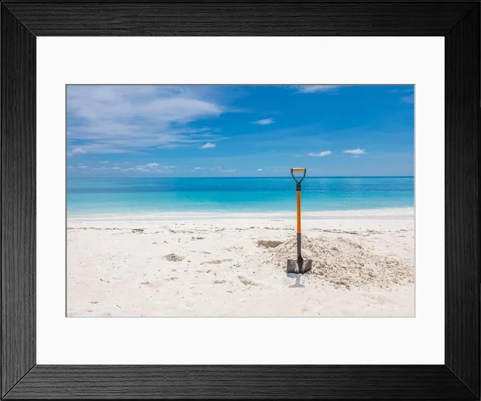 Framed Print : Shovel in Sand at the Beach. Wide angle image of a shovel in the sand on a beach under a partly cloudy blue sky Framed Print : Shovel in Sand at the Beach. Wide angle image of a shovel in the sand on a beach under a partly cloudy blue sky