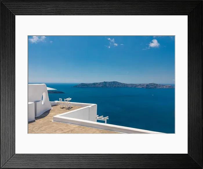 Framed Print : White architecture on Santorini island, Greece. Outdoor restaurant under a fantastic landscape, chairs for couple. Romantic view, summer vacation Framed Print : White architecture on Santorini island, Greece. Outdoor restaurant under a fantastic landscape, chairs for couple. Romantic view, summer vacation