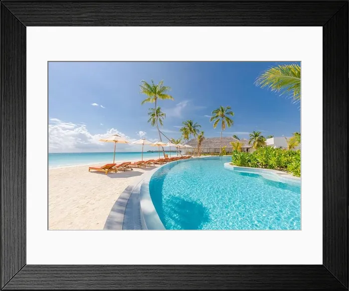 Framed Print : Summer tourism landscape. Luxurious beach resort with swimming pool and beach chairs or loungers under umbrellas with palm trees and blue sky vacation Framed Print : Summer tourism landscape. Luxurious beach resort with swimming pool and beach chairs or loungers under umbrellas with palm trees and blue sky vacation