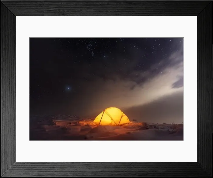 Framed Print : Yellow tent lighted from the inside against the backdrop of glowing city lights and incredible starry sky. Amazing night landscape