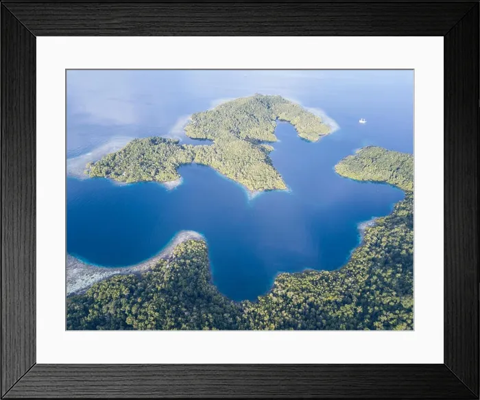 Framed Print : Beautiful, tropical islands rise from the seascape in Raja Ampat, Indonesia. This remote region is known as the heart of the Coral Triangle Framed Print : Beautiful, tropical islands rise from the seascape in Raja Ampat, Indonesia. This remote region is known as the heart of the Coral Triangle