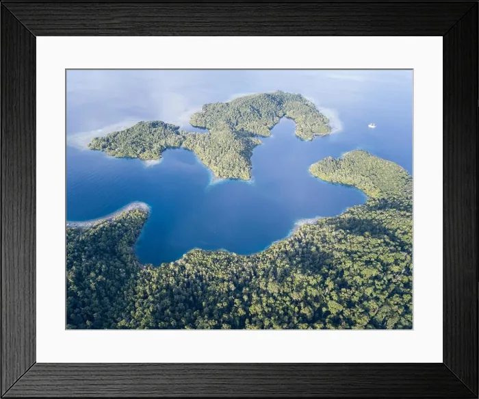 Framed Print : Beautiful, tropical islands rise from the seascape in Raja Ampat, Indonesia. This remote region is known as the heart of the Coral Triangle Framed Print : Beautiful, tropical islands rise from the seascape in Raja Ampat, Indonesia. This remote region is known as the heart of the Coral Triangle