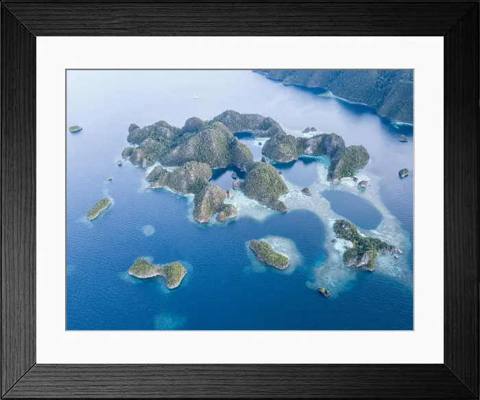 Framed Print : Beautiful limestone islands rise from the calm seas of Raja Ampat, Indonesia. This remote region is known for its extraordinary marine biodiversity Framed Print : Beautiful limestone islands rise from the calm seas of Raja Ampat, Indonesia. This remote region is known for its extraordinary marine biodiversity