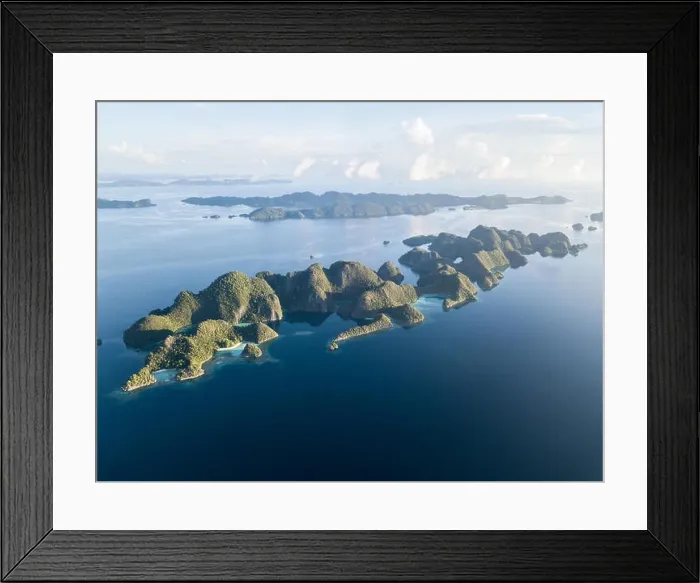 Framed Print : Amazing limestone islands rise from the calm seascape around Misool, Raja Ampat, Indonesia. This tropical region harbors amazing marine biodiversity Framed Print : Amazing limestone islands rise from the calm seascape around Misool, Raja Ampat, Indonesia. This tropical region harbors amazing marine biodiversity