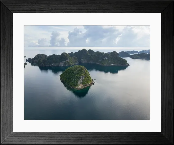 Framed Print : Amazing limestone islands rise from the calm seascape around Misool, Raja Ampat, Indonesia. This tropical region harbors amazing marine biodiversity Framed Print : Amazing limestone islands rise from the calm seascape around Misool, Raja Ampat, Indonesia. This tropical region harbors amazing marine biodiversity