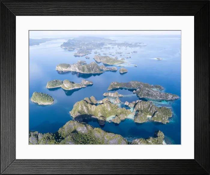 Framed Print : Amazing limestone islands rise from the calm seascape around Misool, Raja Ampat, Indonesia. This tropical region harbors amazing marine biodiversity Framed Print : Amazing limestone islands rise from the calm seascape around Misool, Raja Ampat, Indonesia. This tropical region harbors amazing marine biodiversity