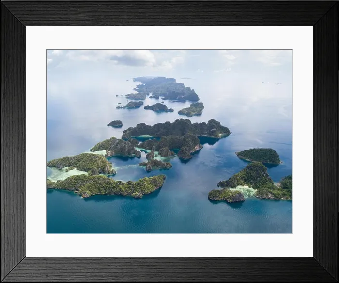 Framed Print : The remote limestone islands of Misool in Raja Ampat are surrounded by calm seas and healthy reefs. This tropical region has high marine biodiversity Framed Print : The remote limestone islands of Misool in Raja Ampat are surrounded by calm seas and healthy reefs. This tropical region has high marine biodiversity