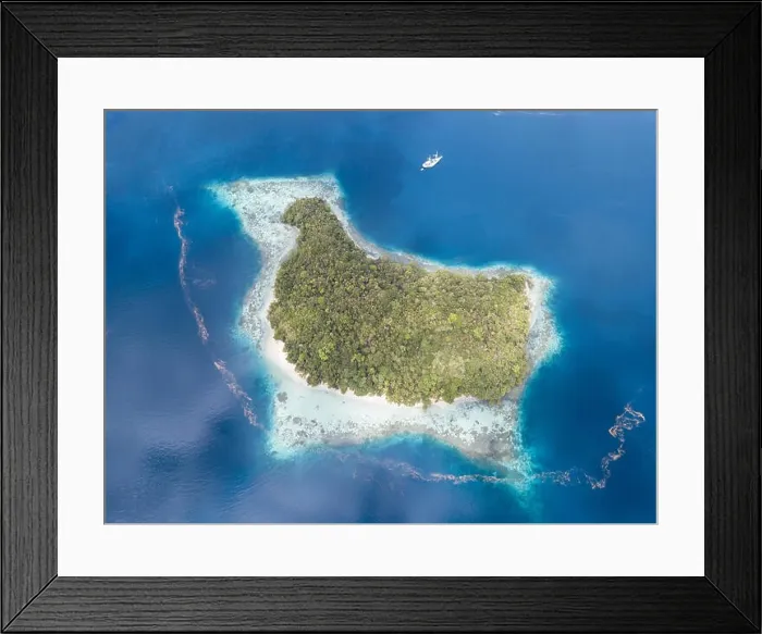 Framed Print : The remote limestone islands in Raja Ampat are surrounded by calm seas and healthy reefs. This tropical region has high marine biodiversity