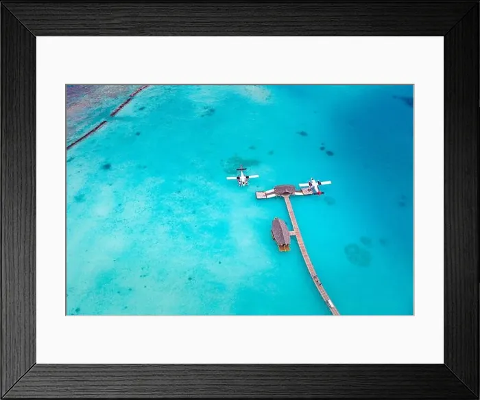Framed Print : Beautiful aerial view of Maldives jetty seaplane top view with wooden boat Dhoni and tropical beach, jetty over wonderful blue sea. Luxury travel