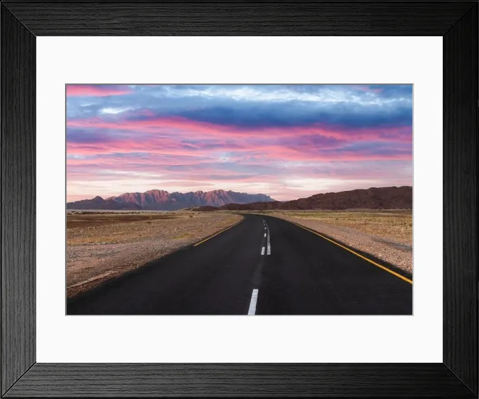 Framed Print : Asphalt road through desert savanna in of Namib at Namib-Naukluft National Park in Namibia, Africa. Highway and sunset sky