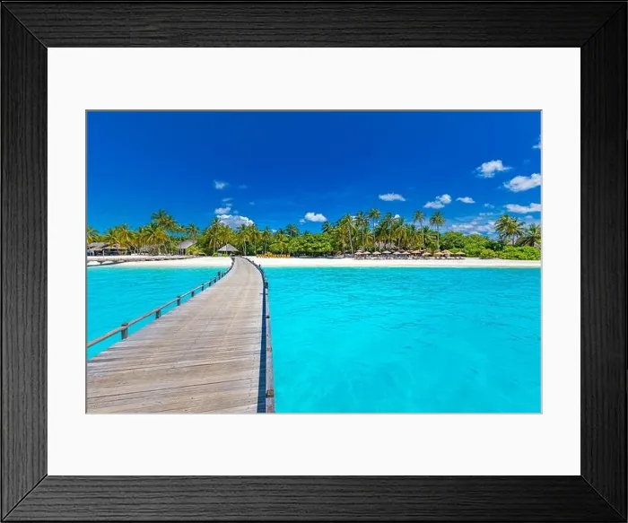 Framed Print : Maldives beach resort panoramic landscape. Tropical vacation beach. Long wooden pier, jetty into paradise island, palm trees, white sand, blue sky Framed Print : Maldives beach resort panoramic landscape. Tropical vacation beach. Long wooden pier, jetty into paradise island, palm trees, white sand, blue sky