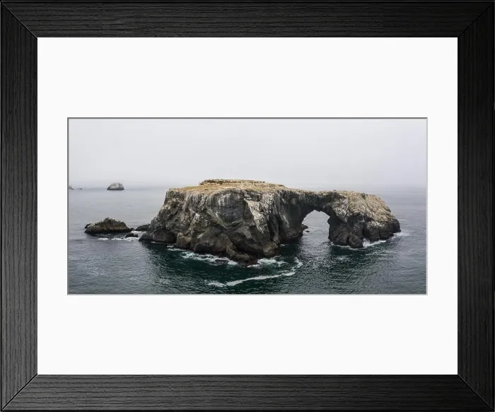 Framed Print : A massive sea stack, formed by the erosive powers of wind and water, rests near the wild, fog-covered coast of northern California Framed Print : A massive sea stack, formed by the erosive powers of wind and water, rests near the wild, fog-covered coast of northern California