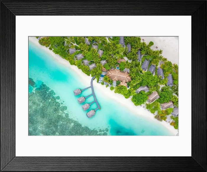 Framed Print : Aerial landscape from drone view blue water and wooden bridge and water villas with paradise island shore, sea coast palm tree. Stunning aerial travel Framed Print : Aerial landscape from drone view blue water and wooden bridge and water villas with paradise island shore, sea coast palm tree. Stunning aerial travel
