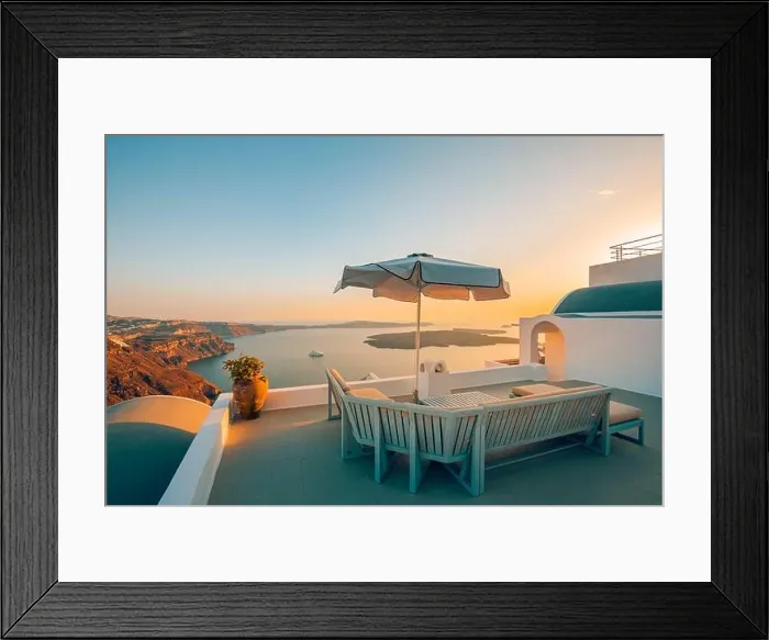 Framed Print : Terrace at sunset in Santorini Island, Greece. Beautiful resort caldera view sunset sky. Relax vibes, umbrella and chairs, table. Summer vacation Framed Print : Terrace at sunset in Santorini Island, Greece. Beautiful resort caldera view sunset sky. Relax vibes, umbrella and chairs, table. Summer vacation