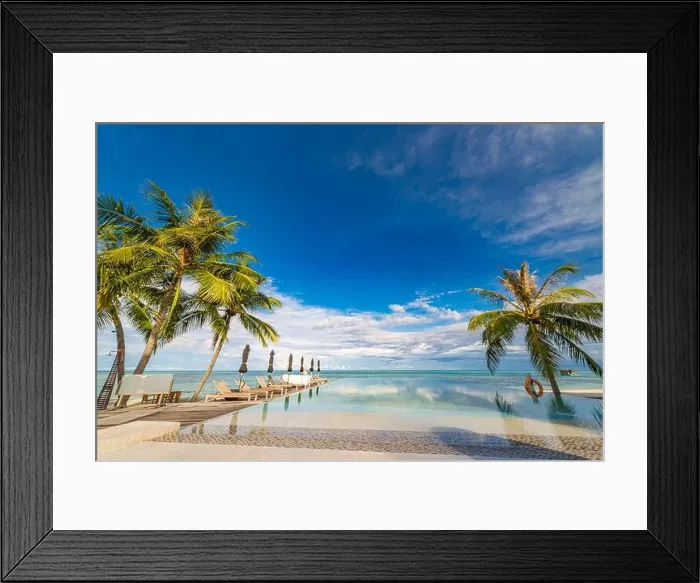 Framed Print : Outdoor tourism landscape. Luxurious beach resort with swimming pool and beach chairs or loungers under umbrellas with palm trees and blue sky. Summer Framed Print : Outdoor tourism landscape. Luxurious beach resort with swimming pool and beach chairs or loungers under umbrellas with palm trees and blue sky. Summer