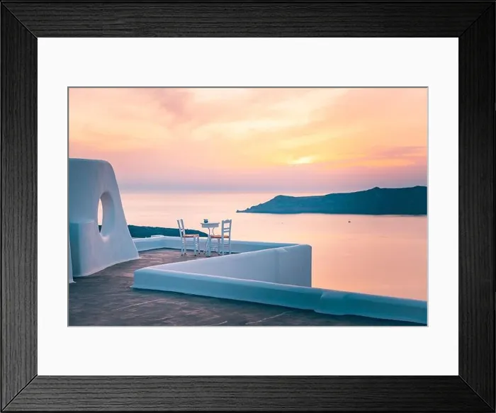 Framed Print : White architecture on Santorini island, Greece. Outdoor restaurant under a fantastic sunset landscape, chairs for couple. Romantic sunset view Framed Print : White architecture on Santorini island, Greece. Outdoor restaurant under a fantastic sunset landscape, chairs for couple. Romantic sunset view