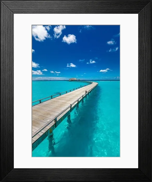 Framed Print : Maldives villa on piles on water, luxury summer travel. Morning sunlight, long wooden jetty under cloudy blue sky. Luxury bungalows, amazing sea Framed Print : Maldives villa on piles on water, luxury summer travel. Morning sunlight, long wooden jetty under cloudy blue sky. Luxury bungalows, amazing sea