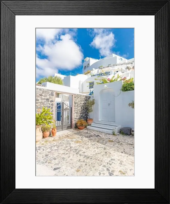Framed Print : Scenic view of traditional cycladic Santorini houses on small street, old stone path, white architecture and blue sky. Summer travel vacation, idyllic Framed Print : Scenic view of traditional cycladic Santorini houses on small street, old stone path, white architecture and blue sky. Summer travel vacation, idyllic