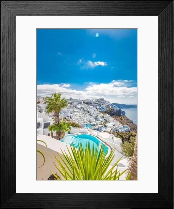 Framed Print : View of caldera and swimming pool in foreground, typical white architecture village on Santorini island, Greece. Summer vacations background. Luxury