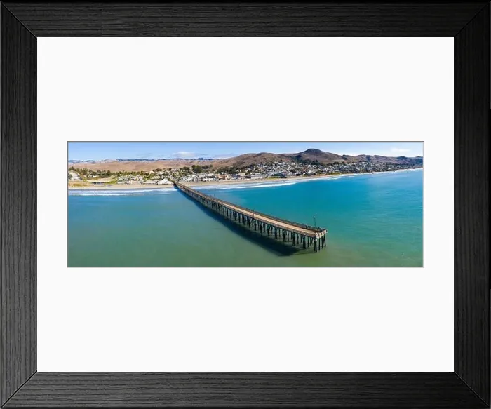 Framed Print : A long pier reaches out into the Pacific Coast in the quaint city of Cayucos, California. This California region is known for its coastal scenery Framed Print : A long pier reaches out into the Pacific Coast in the quaint city of Cayucos, California. This California region is known for its coastal scenery