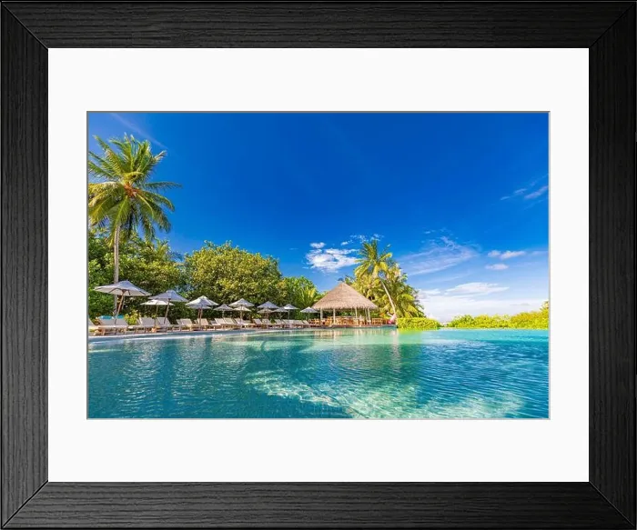 Framed Print : tourism landscape. Luxurious beach resort with swimming pool and beach chairs or loungers under umbrellas with palm trees and blue sky. Summer island Framed Print : tourism landscape. Luxurious beach resort with swimming pool and beach chairs or loungers under umbrellas with palm trees and blue sky. Summer island