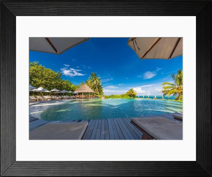Framed Print : tourism landscape. Luxurious beach resort with swimming pool and beach chairs or loungers under umbrellas with palm trees and blue sky. Summer island Framed Print : tourism landscape. Luxurious beach resort with swimming pool and beach chairs or loungers under umbrellas with palm trees and blue sky. Summer island
