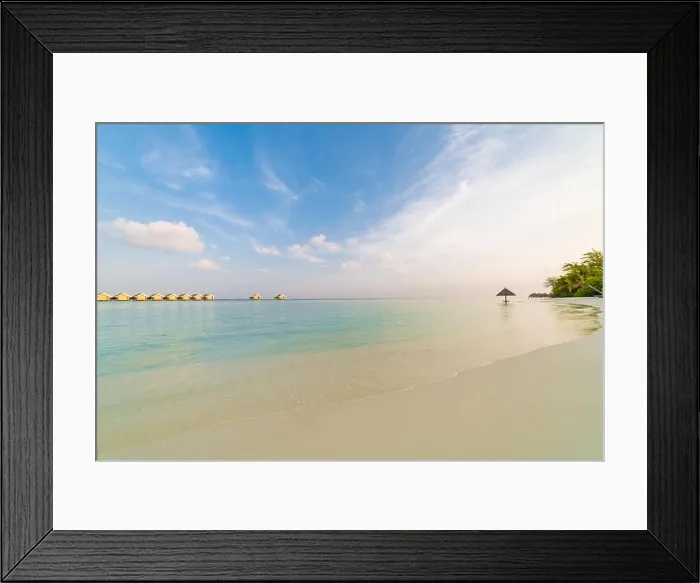 Framed Print : Amazing Maldives scenery, water villas and beach umbrella with palm trees. Tranquil sunset landscape in tropical beach. Luxury vacation destination Framed Print : Amazing Maldives scenery, water villas and beach umbrella with palm trees. Tranquil sunset landscape in tropical beach. Luxury vacation destination