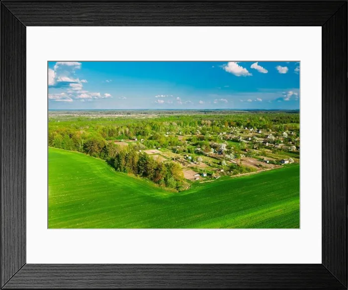 Framed Print : Countryside Rural Green Field Landscape With Young Wheat Sprouts And Small Russian Village In Spring Summer Cloudy Day. Agricultural Field. Young Framed Print : Countryside Rural Green Field Landscape With Young Wheat Sprouts And Small Russian Village In Spring Summer Cloudy Day. Agricultural Field. Young