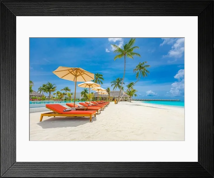 Framed Print : Outdoor tourism landscape. Luxurious beach resort with swimming pool and beach chairs or loungers under umbrellas with palm trees and blue sky. Summer