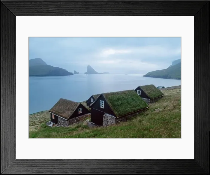 Framed Print : Picturesque view of tradicional faroese grass-covered houses in the village Bour. Drangarnir and Tindholmur sea stacks on background. Vagar island, Fa Framed Print : Picturesque view of tradicional faroese grass-covered houses in the village Bour. Drangarnir and Tindholmur sea stacks on background. Vagar island, Fa