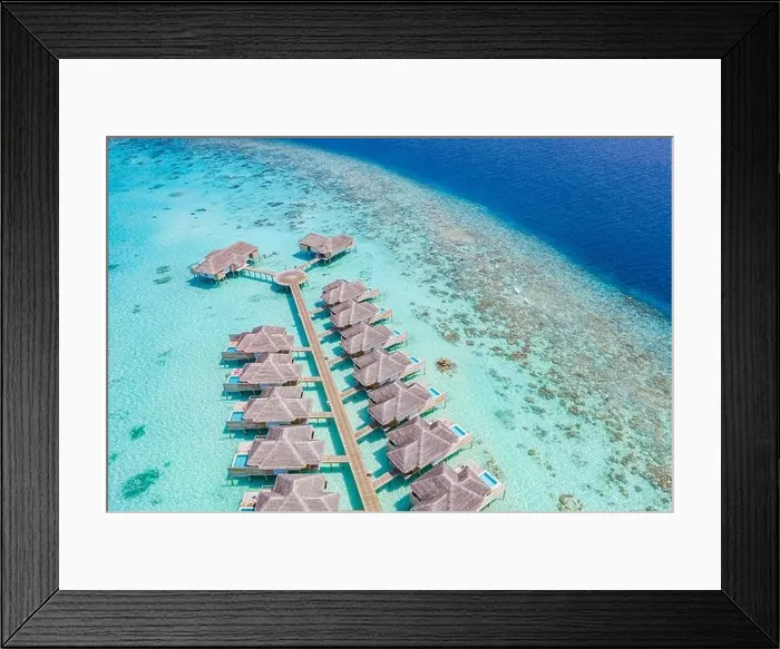 Framed Print : Aerial view of Maldives island, luxury water villas resort and wooden pier. Beautiful sky and ocean lagoon beach background. Summer vacation holiday Framed Print : Aerial view of Maldives island, luxury water villas resort and wooden pier. Beautiful sky and ocean lagoon beach background. Summer vacation holiday