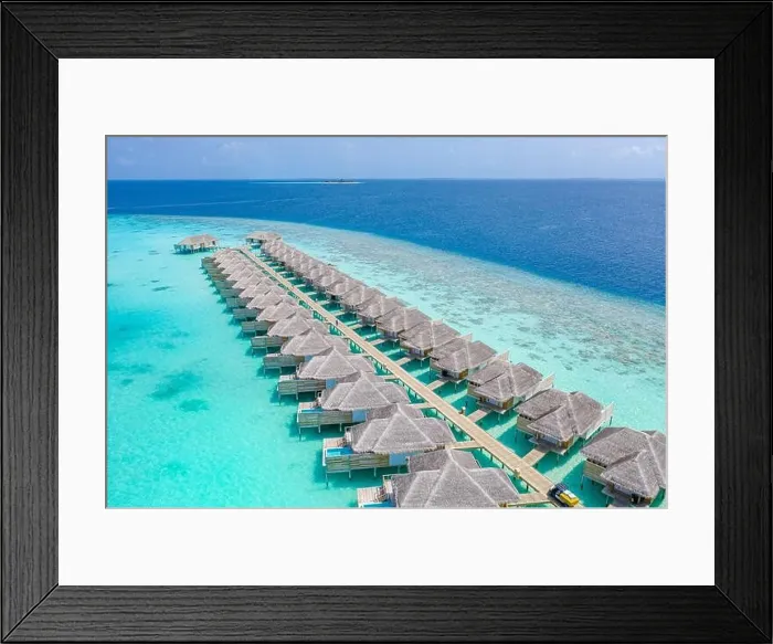 Framed Print : Aerial view of Maldives island, luxury water villas resort and wooden pier. Beautiful sky and ocean lagoon beach background. Summer vacation holiday Framed Print : Aerial view of Maldives island, luxury water villas resort and wooden pier. Beautiful sky and ocean lagoon beach background. Summer vacation holiday