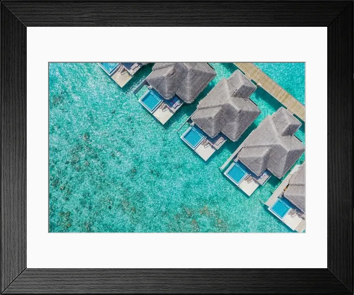 Framed Print : Aerial view of Maldives island, luxury water villas resort and wooden pier. Beautiful sky and ocean lagoon beach background. Summer vacation holiday Framed Print : Aerial view of Maldives island, luxury water villas resort and wooden pier. Beautiful sky and ocean lagoon beach background. Summer vacation holiday