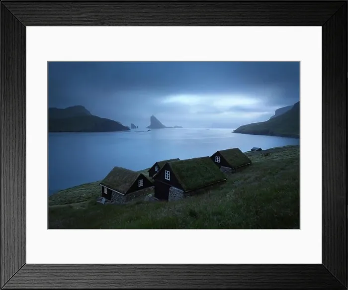 Framed Print : Picturesque view of tradicional faroese grass-covered houses in the village Bour. Drangarnir and Tindholmur sea stacks on background Framed Print : Picturesque view of tradicional faroese grass-covered houses in the village Bour. Drangarnir and Tindholmur sea stacks on background