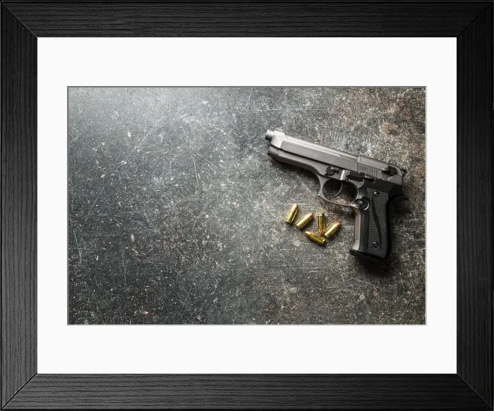 Framed Print : 9mm pistol bullets and handgun on black table Framed Print : 9mm pistol bullets and handgun on black table