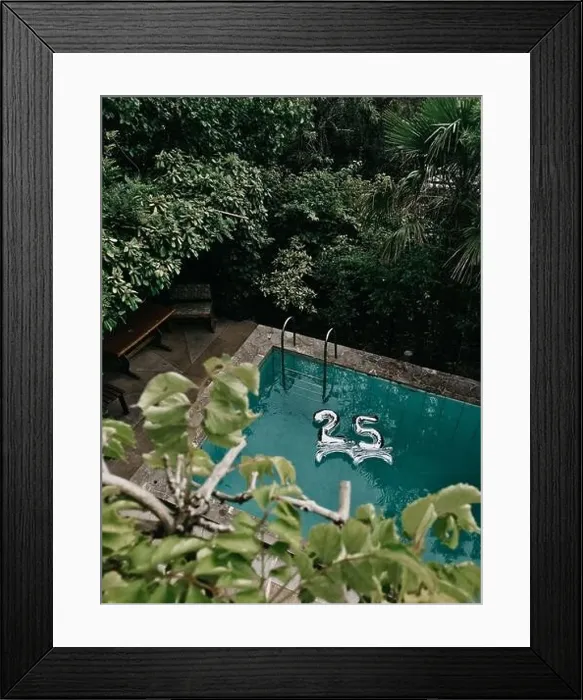 Framed Print : Floating balloons, silver 25 number in the cyan swimming pool. Green trees and leaves around aqua colored water Framed Print : Floating balloons, silver 25 number in the cyan swimming pool. Green trees and leaves around aqua colored water