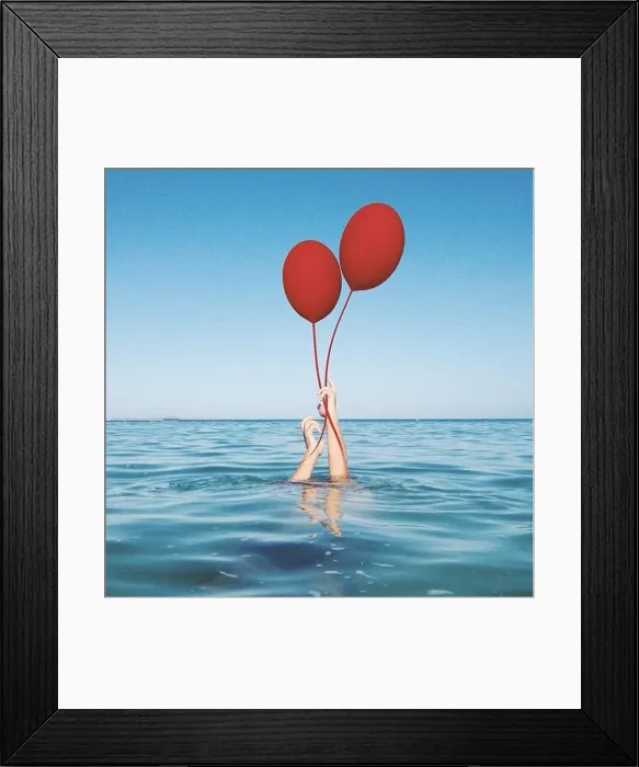 Framed Print : Human hands coming out of the sea holding two balloons