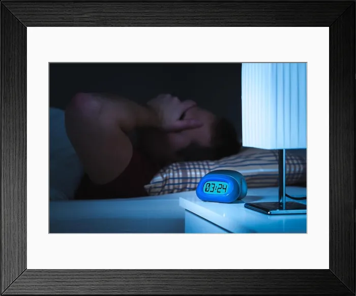 Framed Print : Insomnia and sleepless concept. Man unable to sleep. Exhausted and tired. Covering face with hand. Alarm clock on nightstand and bed in bedroom Framed Print : Insomnia and sleepless concept. Man unable to sleep. Exhausted and tired. Covering face with hand. Alarm clock on nightstand and bed in bedroom