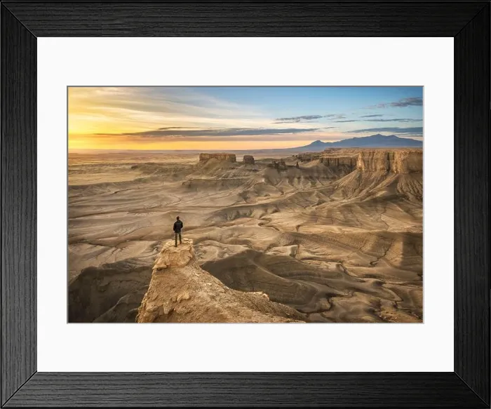 Framed Print : One person standing on rock outcrop in a dramatic desert landscape Framed Print : One person standing on rock outcrop in a dramatic desert landscape