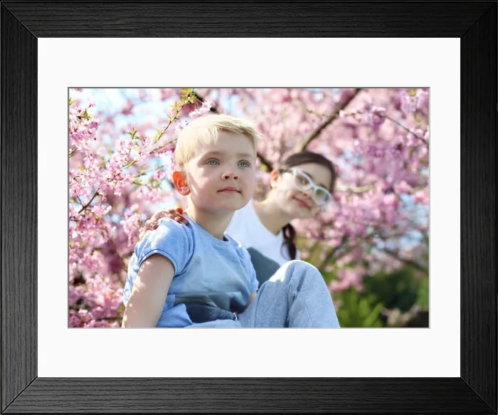 Framed Print : Siblings. Happy child. Boy sitting under a tree, the girl in the backgroun Framed Print : Siblings. Happy child. Boy sitting under a tree, the girl in the backgroun