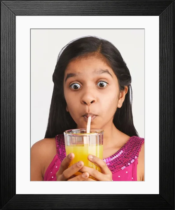 Framed Print : YOUNG INDIAN GIRL DRINKING ORANGE JUICE. SHOT AGAINST A PLAIN BACKGROUND Framed Print : YOUNG INDIAN GIRL DRINKING ORANGE JUICE. SHOT AGAINST A PLAIN BACKGROUND