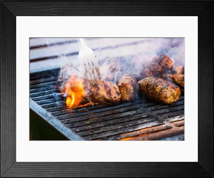 Framed Print : Preparing meat rolls called mici or mititei on barbecue. close up of grill with burning fire with flame and smoke