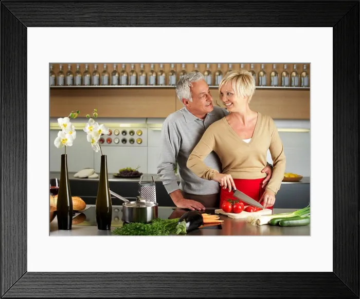 Framed Print : Blond woman and gray-haired man cooking together Framed Print : Blond woman and gray-haired man cooking together