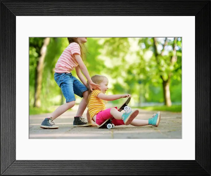 Framed Print : Two pretty little girls learning to skateboard on beautiful summer day in a park. Children enjoying skateboarding ride outdoors Framed Print : Two pretty little girls learning to skateboard on beautiful summer day in a park. Children enjoying skateboarding ride outdoors