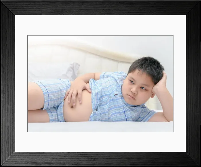Framed Print : Obese fat boy lying show stomach on bed, lazy and unhealthy concept Framed Print : Obese fat boy lying show stomach on bed, lazy and unhealthy concept