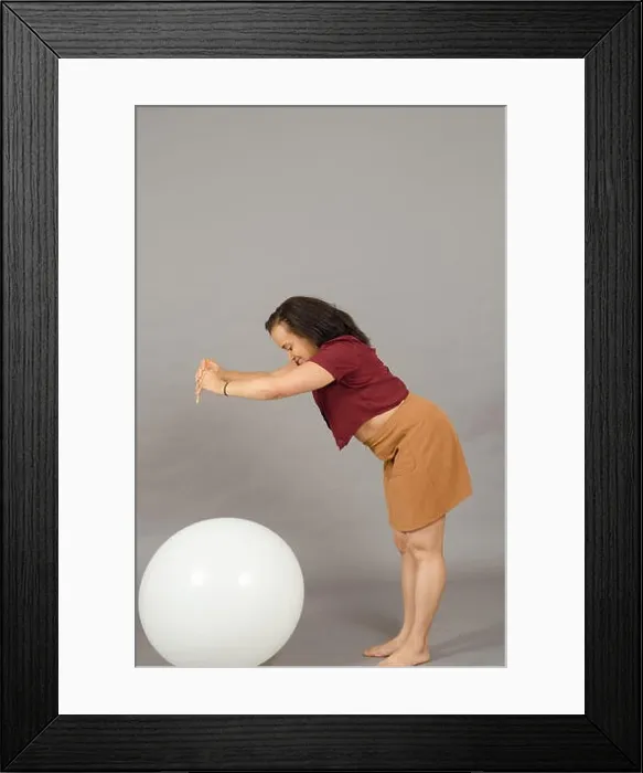 Framed Print : Adult woman bursting a huge balloon with a pencil Framed Print : Adult woman bursting a huge balloon with a pencil
