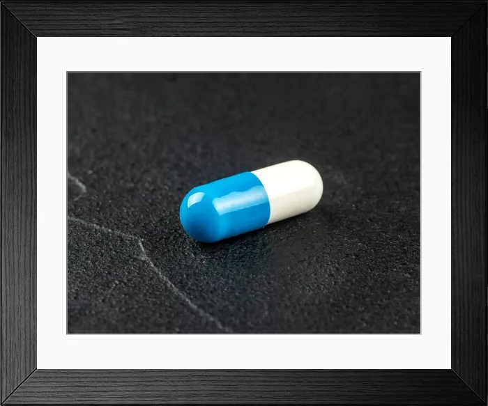 Framed Print : Blue white capsule on dark concrete background Framed Print : Blue white capsule on dark concrete background