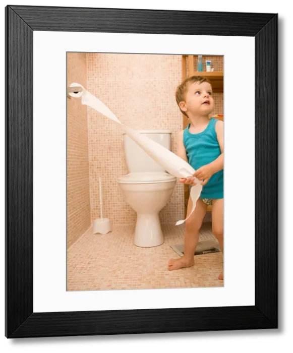 Framed Print : Little boy in bathroom, playing with toilet paper Framed Print : Little boy in bathroom, playing with toilet paper
