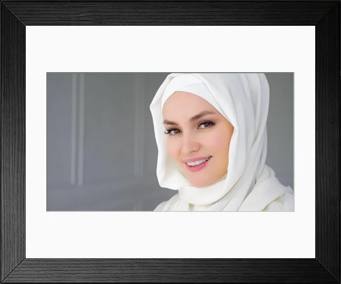 Framed Print : Portrait of beautiful young muslim arabian woman wearing white hijab, slowly rising her eyes looking at camera and smiling Framed Print : Portrait of beautiful young muslim arabian woman wearing white hijab, slowly rising her eyes looking at camera and smiling