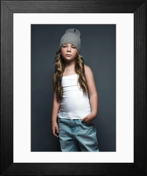 Framed Print : Little girl model professionally posing in the studio in jeans and a white T-shirt. Model tests Framed Print : Little girl model professionally posing in the studio in jeans and a white T-shirt. Model tests